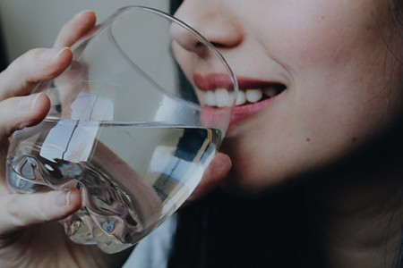 девушка пьет воду из бокала